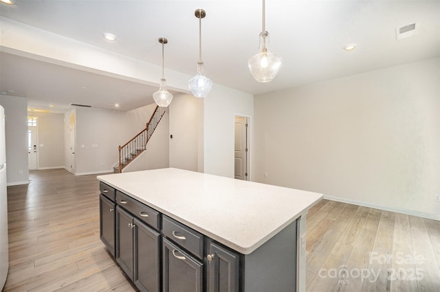 5532 Axil Ln, Charlotte, NC 28269 - kitchen with open floor plan, light countertops, a center island, light wood finished floors, and pendant lighting