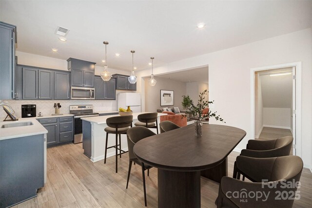 5532 Axil Ln, Charlotte, NC 28269 - kitchen with tasteful backsplash, visible vents, appliances with stainless steel finishes, light countertops, and a sink