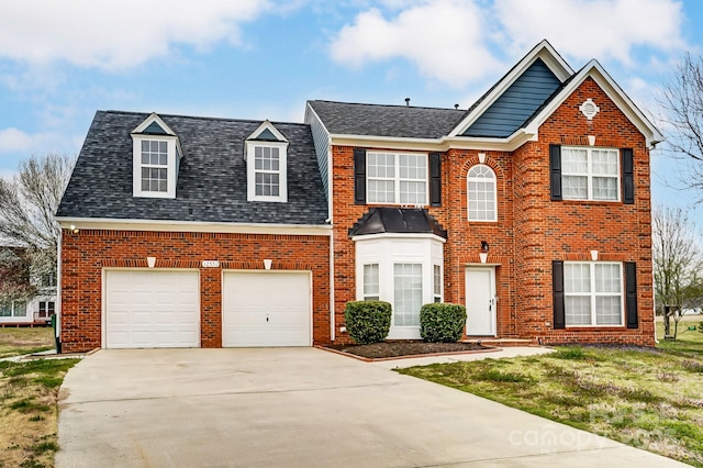 view of front of property featuring brick siding, driveway, a front yard, and roof with shingles