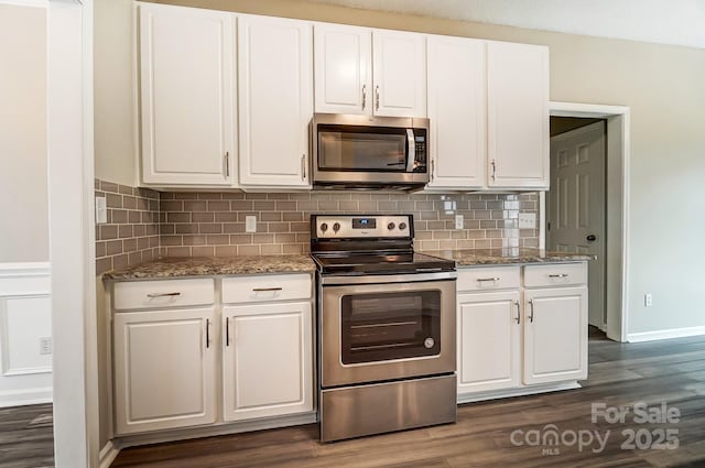 kitchen featuring white cabinets, light stone counters, dark wood-style flooring, and appliances with stainless steel finishes