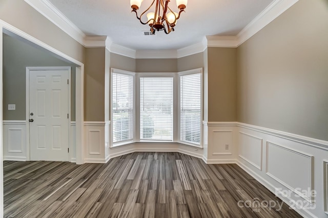 unfurnished dining area with a notable chandelier, dark wood-style floors, visible vents, and ornamental molding