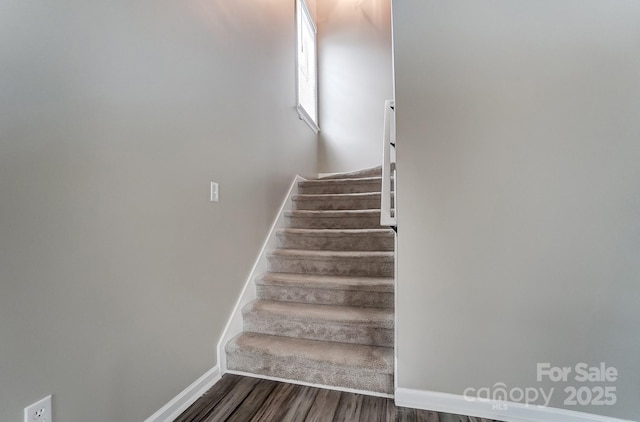 stairs featuring wood finished floors and baseboards