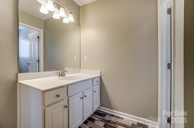 bathroom with vanity, baseboards, and wood finished floors