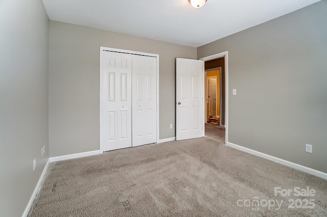 unfurnished bedroom featuring a closet, carpet flooring, and baseboards