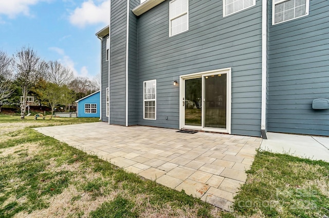 rear view of house with a lawn and a patio