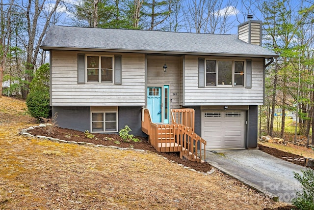 bi-level home with a garage and a chimney