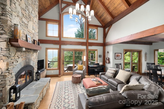 living room with a stone fireplace, wooden ceiling, light wood-style flooring, and a healthy amount of sunlight