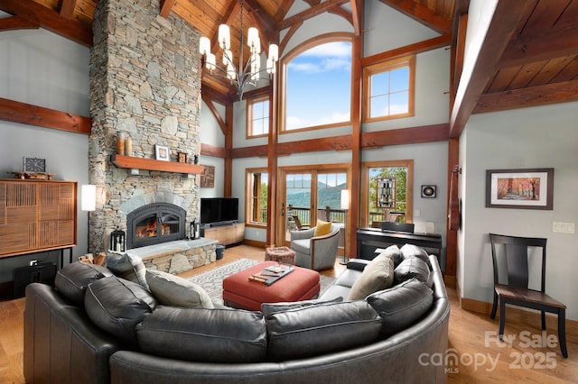 living area featuring wooden ceiling, light wood-style floors, a chandelier, and a fireplace