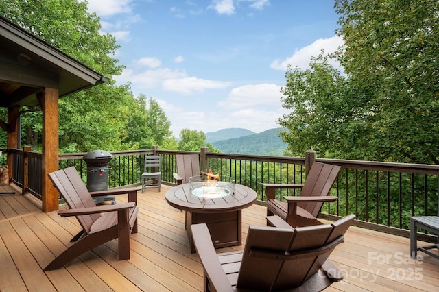 wooden terrace featuring a mountain view and a fire pit