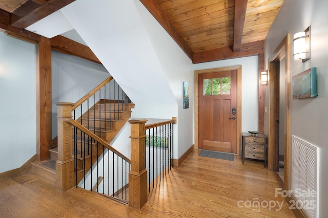 foyer entrance with visible vents, lofted ceiling with beams, wood finished floors, baseboards, and wood ceiling