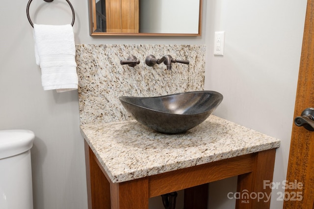 half bath featuring backsplash and vanity