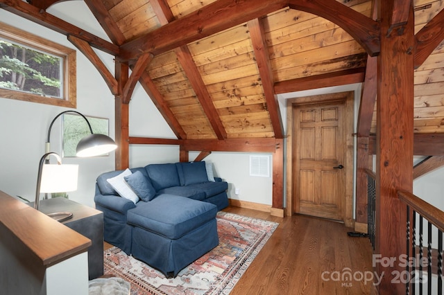 living room with lofted ceiling with beams, wood finished floors, visible vents, and wooden ceiling