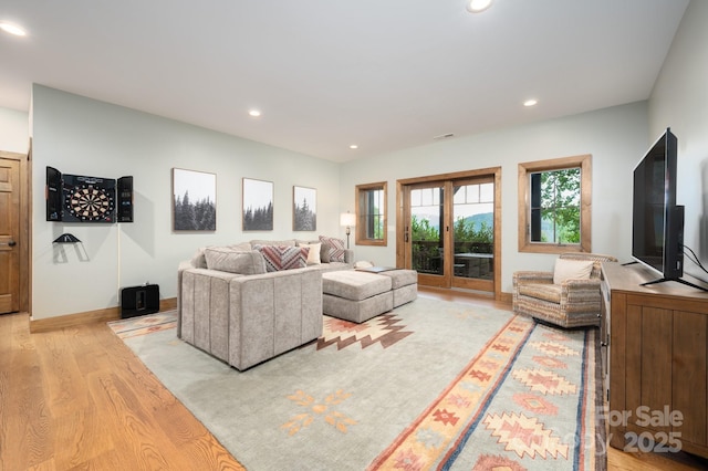 living room with recessed lighting, baseboards, and light wood finished floors