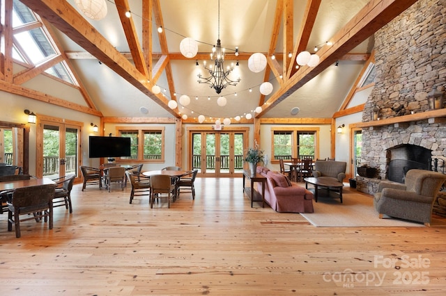 living room with hardwood / wood-style floors, beam ceiling, french doors, and a healthy amount of sunlight