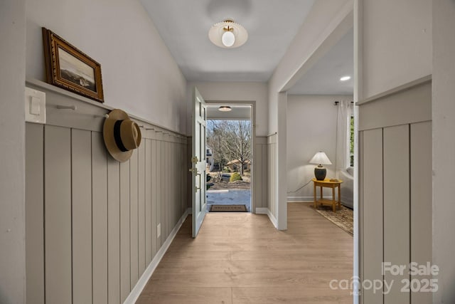 entryway featuring baseboards, light wood-style floors, and a healthy amount of sunlight