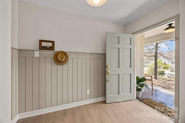 entryway with wainscoting, baseboards, and wood finished floors