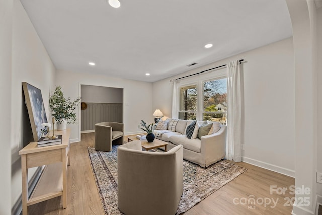 living area with baseboards, visible vents, wood finished floors, and recessed lighting