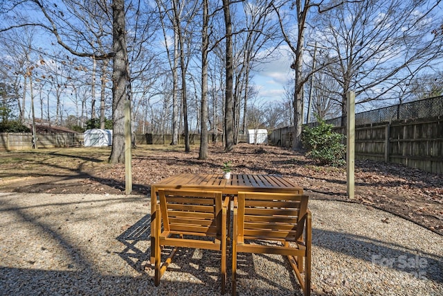 view of yard with a patio area, fence, and outdoor dining area