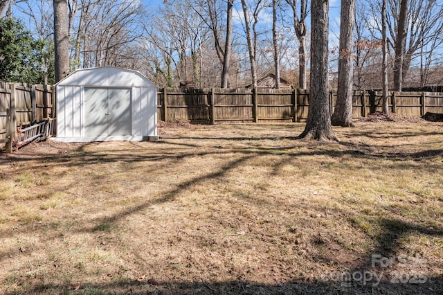 view of yard with a fenced backyard, an outdoor structure, and a shed