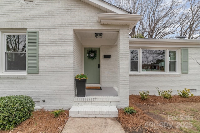 property entrance featuring crawl space and brick siding