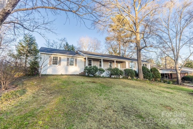 ranch-style house featuring a front yard and covered porch