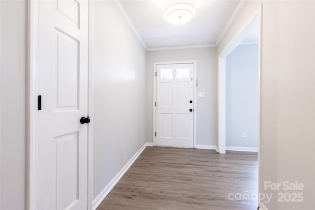 doorway featuring baseboards, ornamental molding, and wood finished floors