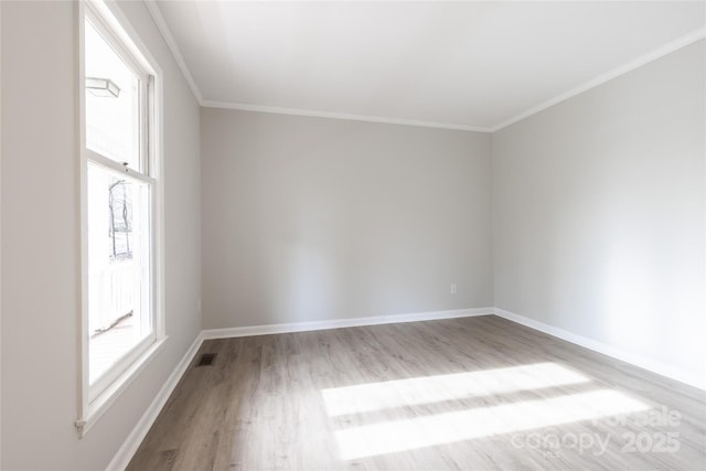 unfurnished room featuring baseboards, ornamental molding, and wood finished floors