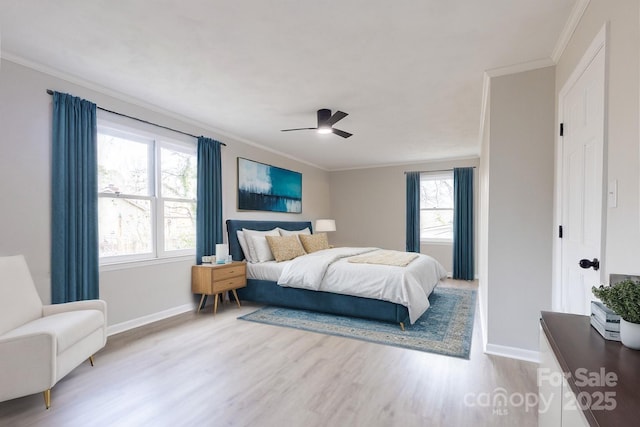 bedroom featuring wood finished floors, crown molding, baseboards, and multiple windows