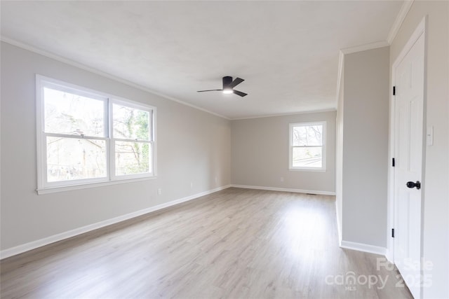 spare room with a ceiling fan, baseboards, ornamental molding, and light wood-style floors