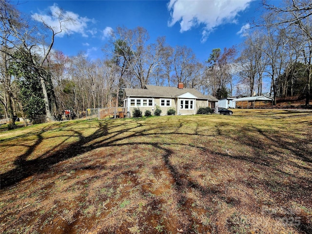 exterior space featuring a front lawn and a chimney