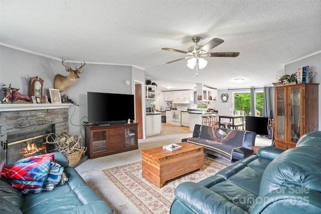 living area featuring crown molding, light colored carpet, a fireplace, a textured ceiling, and a ceiling fan