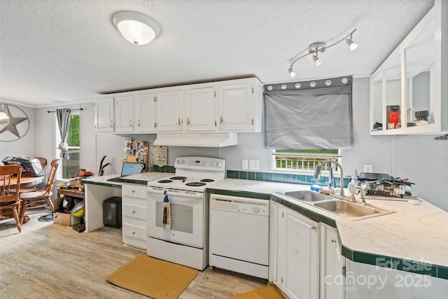 kitchen with a sink, white appliances, a textured ceiling, light wood-style flooring, and under cabinet range hood