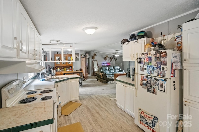 kitchen with a ceiling fan, a textured ceiling, a sink, light wood-style floors, and white appliances