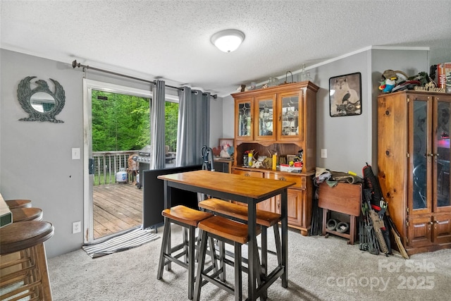dining room featuring a textured ceiling and light carpet