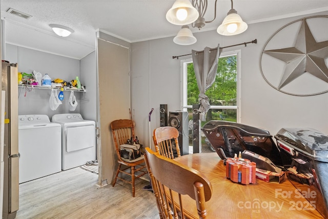 dining area with visible vents, ornamental molding, wood finished floors, and washer and clothes dryer
