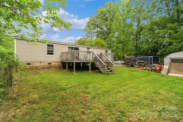 rear view of house featuring a wooden deck, stairway, crawl space, an outdoor structure, and a yard