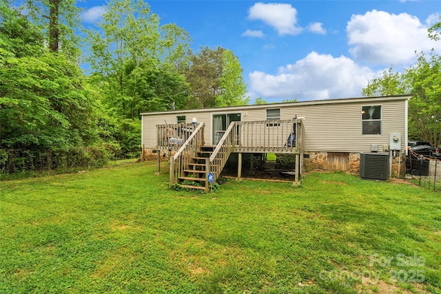 rear view of house featuring fence, a deck, central AC unit, a lawn, and stairway