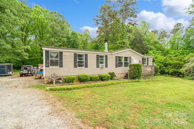 manufactured / mobile home with gravel driveway, crawl space, a front yard, and a deck