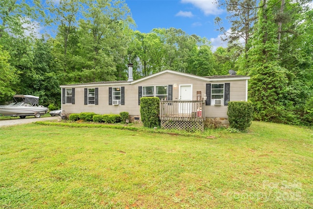 manufactured / mobile home with cooling unit and a front lawn