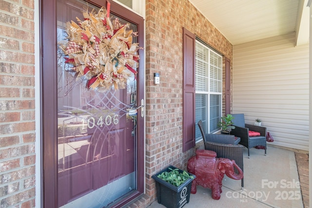 property entrance with brick siding and covered porch