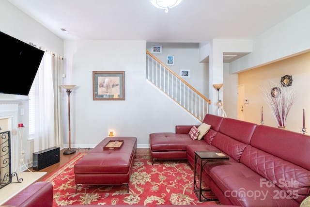 living area with stairway, a fireplace, and baseboards