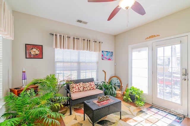 living area featuring visible vents and ceiling fan