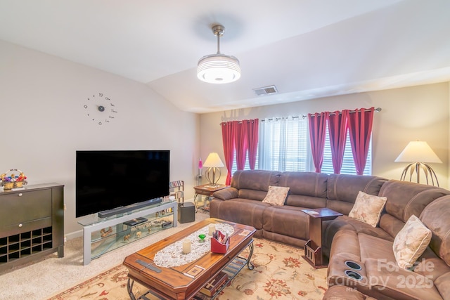 carpeted living area with visible vents and vaulted ceiling