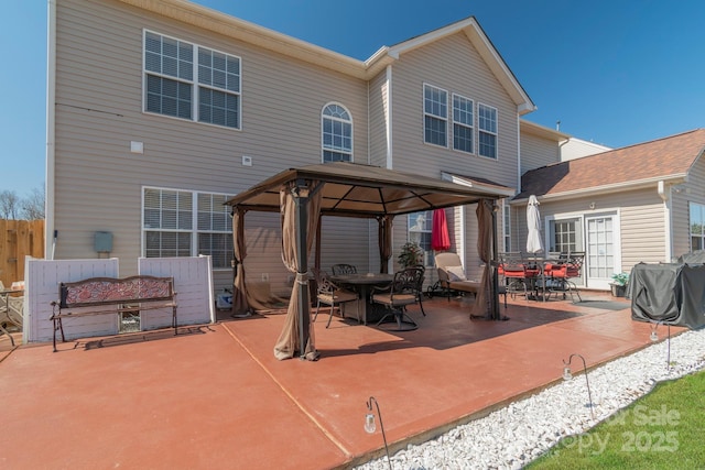 view of patio / terrace with a gazebo, outdoor dining area, fence, and a grill