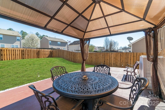 view of patio / terrace with a gazebo, outdoor dining space, and fence