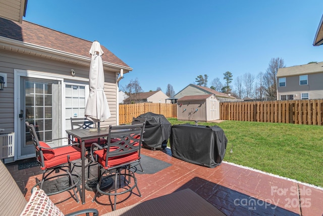 wooden deck featuring grilling area, a storage shed, a yard, outdoor dining space, and a patio