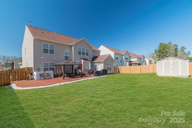 back of house featuring a gazebo, a storage shed, a fenced backyard, an outbuilding, and a patio