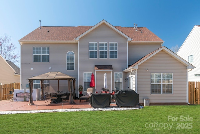 back of property featuring a patio, fence, roof with shingles, a yard, and a gazebo