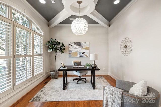 office space with baseboards, ornamental molding, coffered ceiling, and wood finished floors