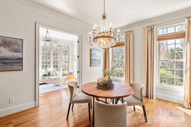 dining area with light wood-style floors, plenty of natural light, and crown molding